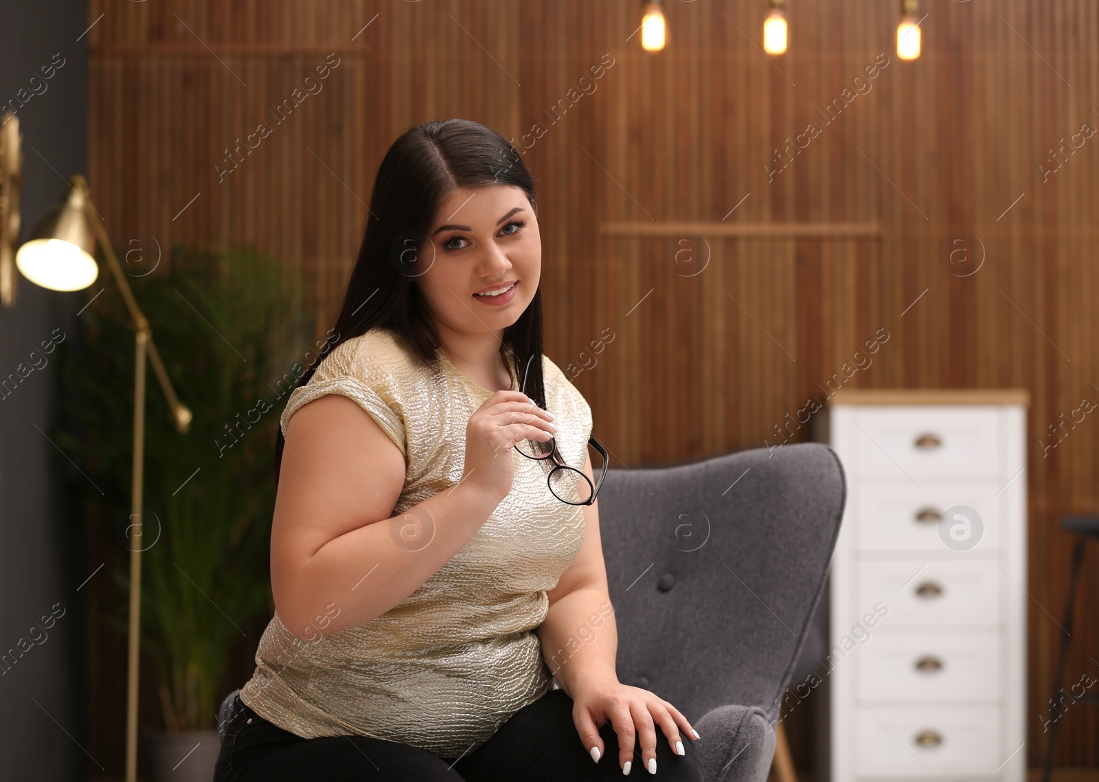 Photo of Beautiful overweight woman posing indoors. Plus size model