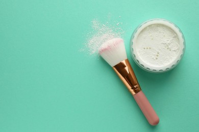 Photo of Rice loose face powder and makeup brush on turquoise background, flat lay. Space for text