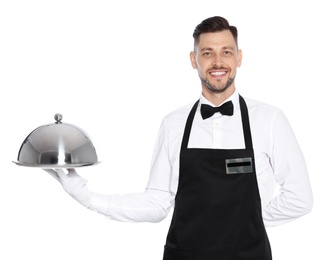 Handsome waiter holding metal tray with lid on white background