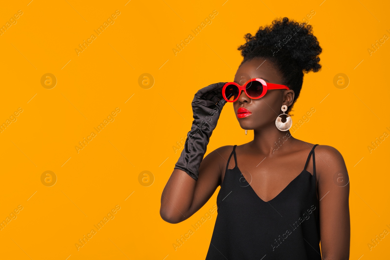 Photo of Fashionable portrait of beautiful woman with stylish sunglasses on yellow background, space for text