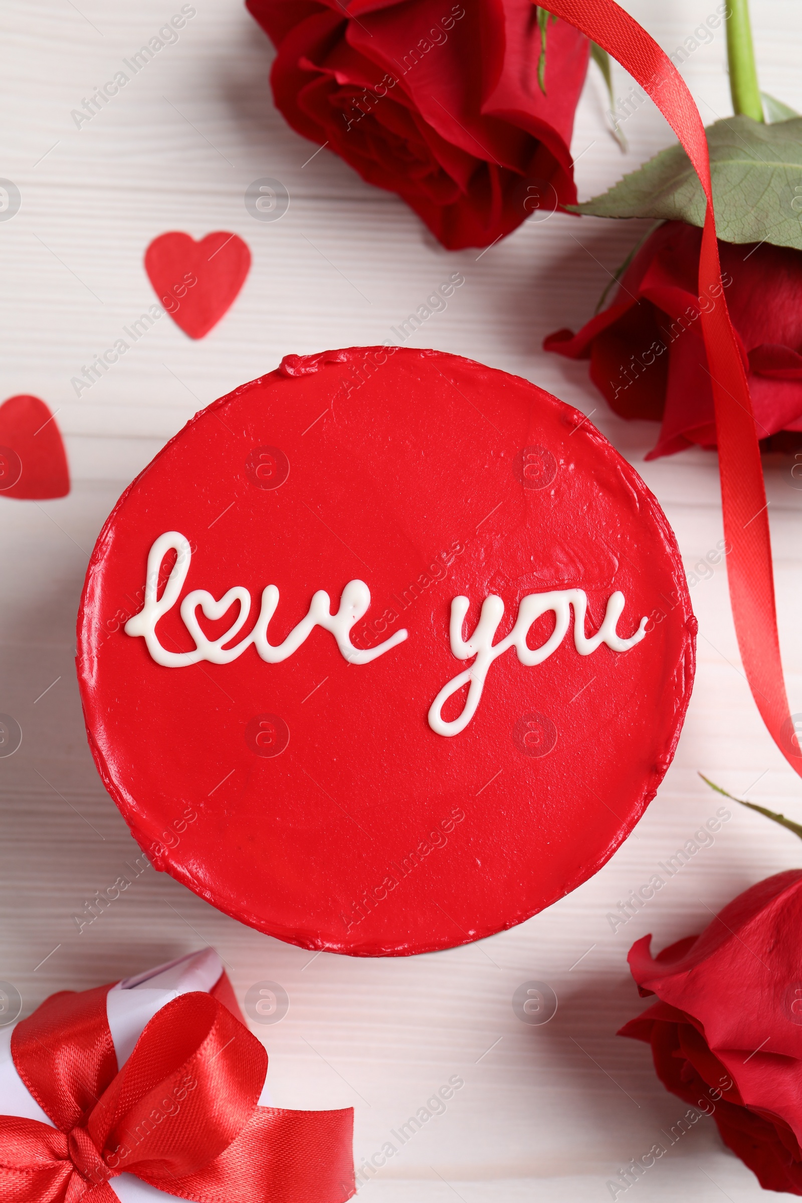 Photo of Bento cake with text Love You, gift box, roses and paper hearts on white wooden table, flat lay. St. Valentine's day surprise