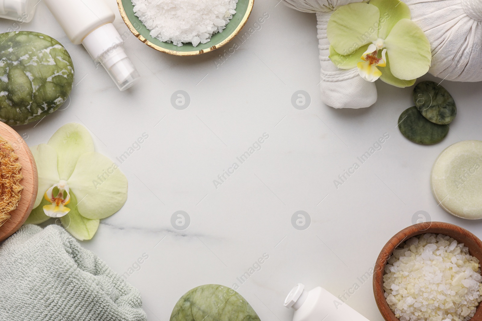 Photo of Frame made of different cosmetic products on white marble table, flat lay and space for text. Spa composition