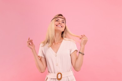 Photo of Portrait of happy hippie woman on pink background
