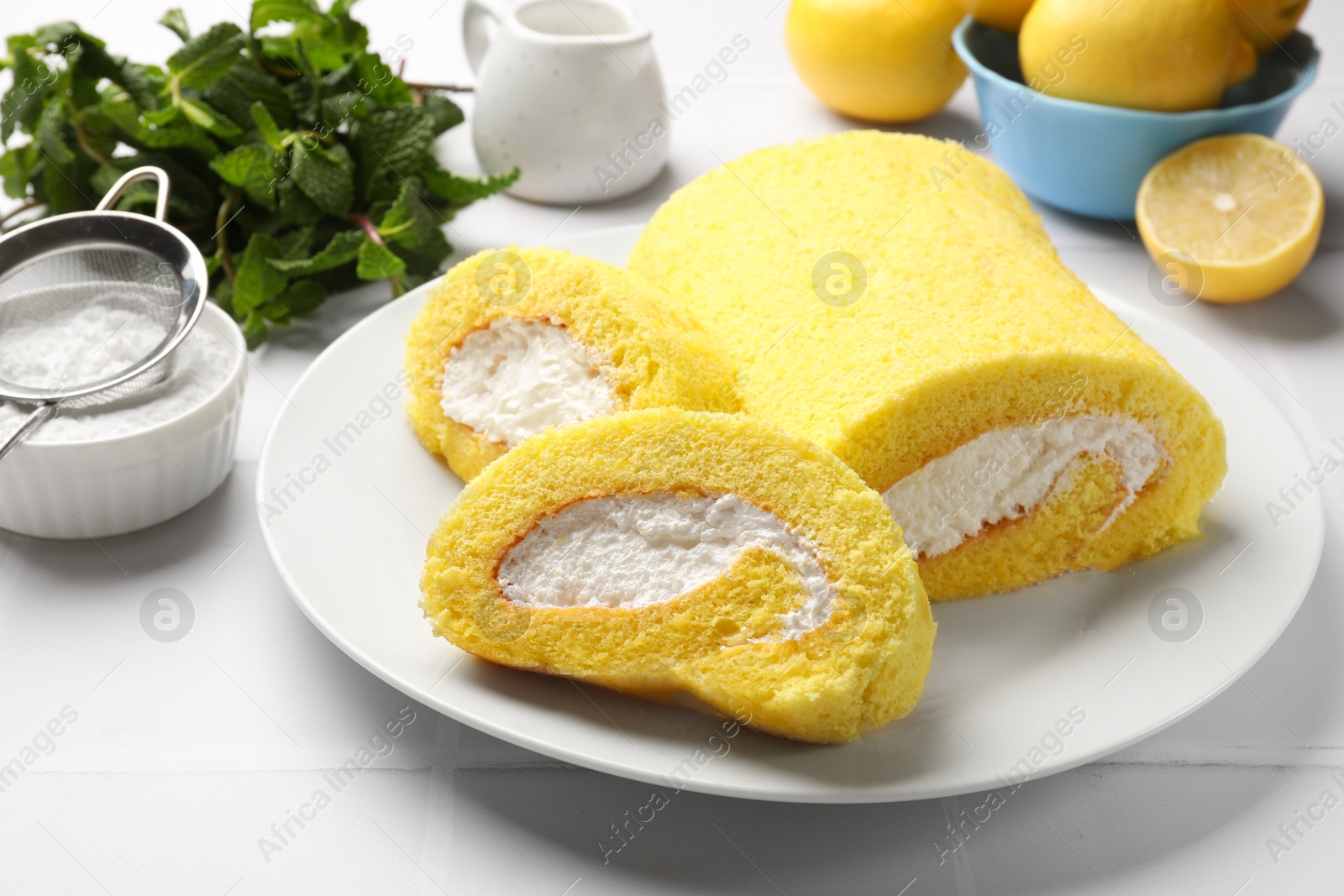 Photo of Delicious cake roll on white tiled table, closeup