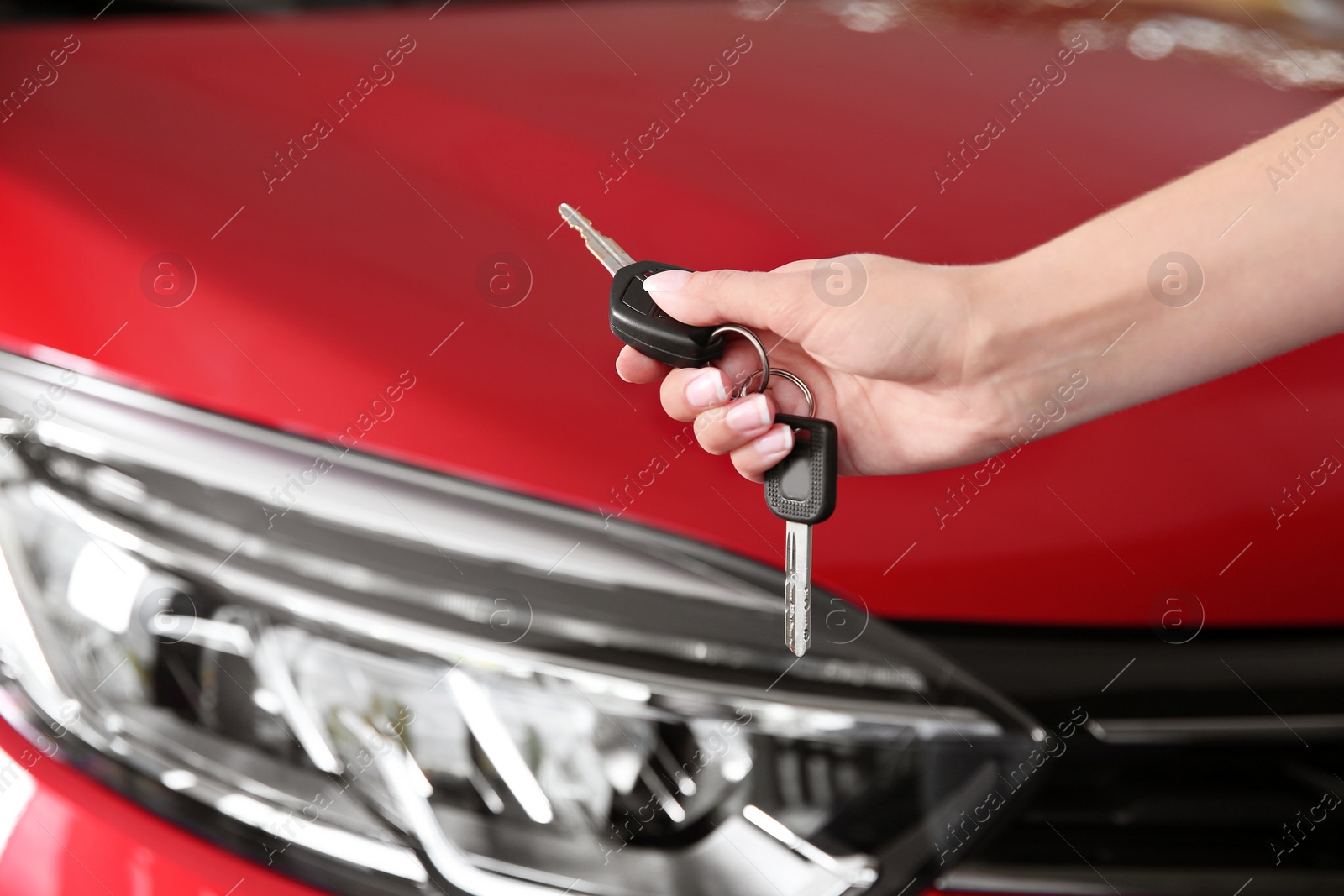 Photo of Woman with car key near new auto, closeup