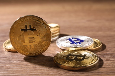 Photo of Shiny bitcoins on wooden background, space for text. Digital currency