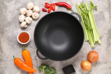 Photo of Wok and different products on grey textured table, flat lay