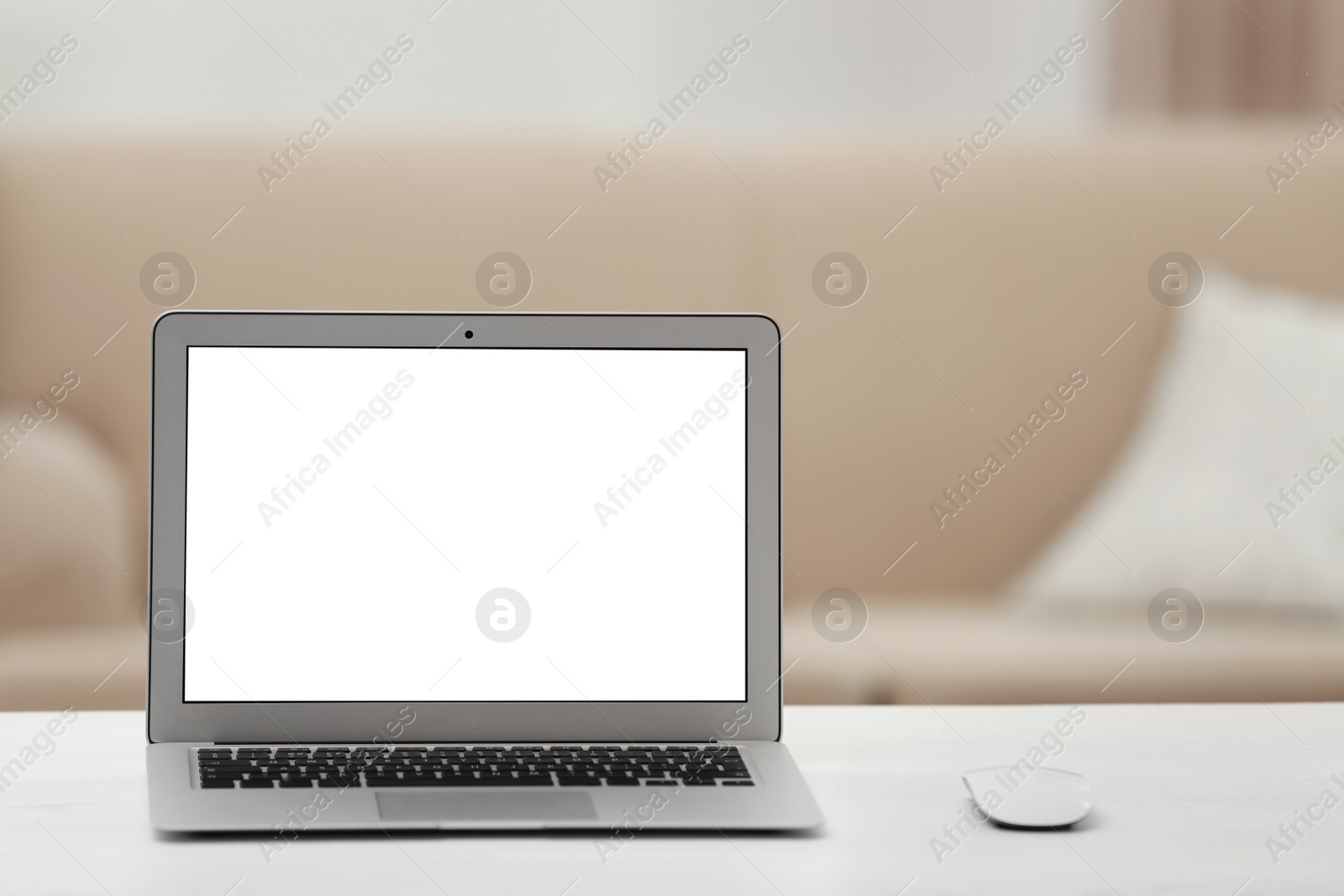 Photo of Laptop with blank screen on table indoors. Space for text