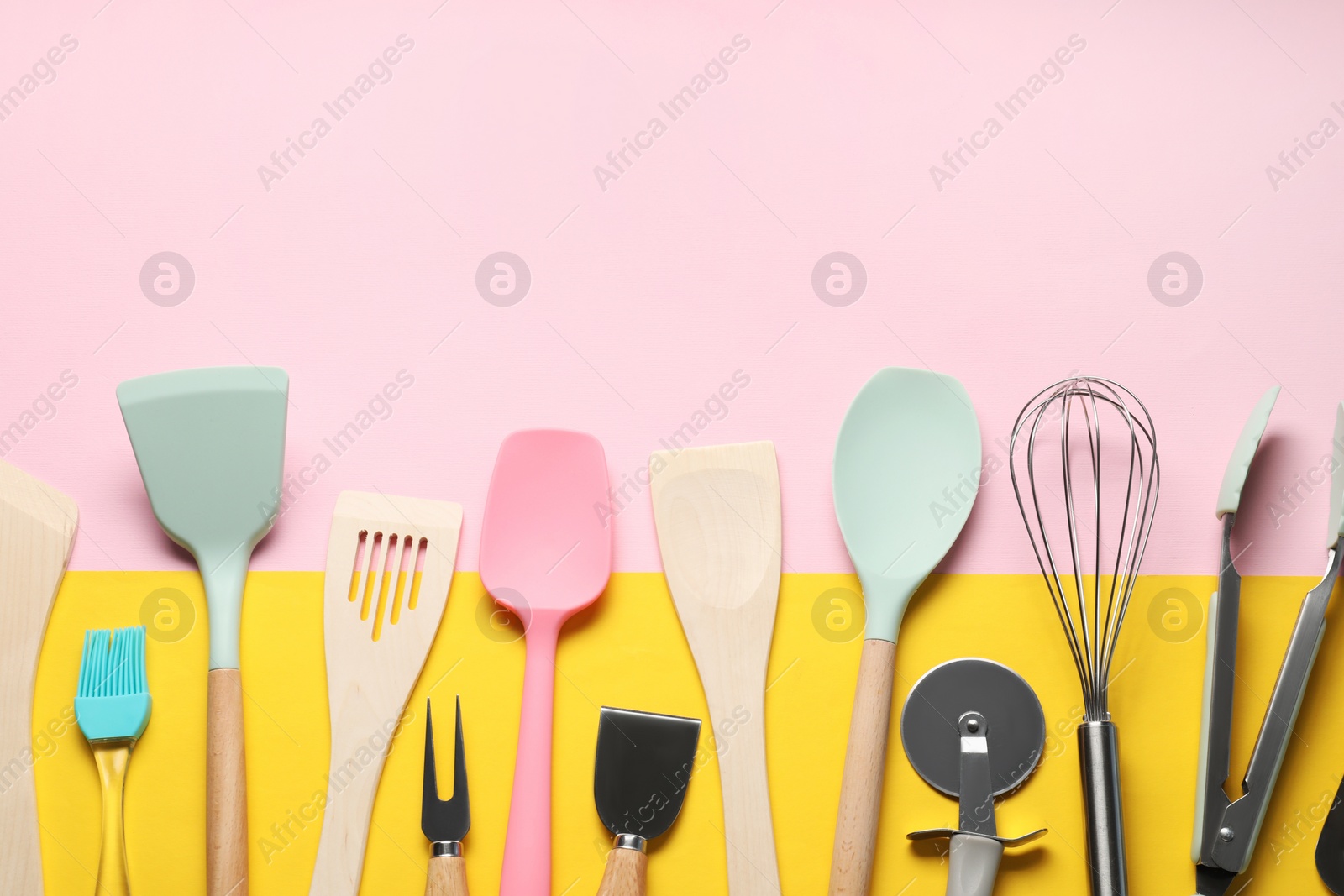 Photo of Different spatulas and other kitchen utensils on color background, flat lay. Space for text