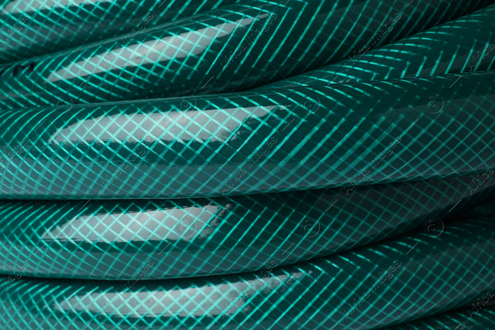 Photo of Green rubber watering hose as background, closeup