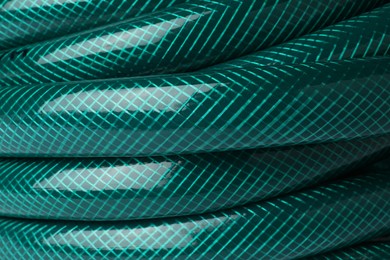 Photo of Green rubber watering hose as background, closeup