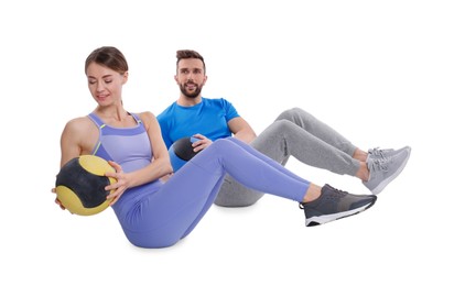 Photo of Athletic couple doing exercise with medicine balls on white background