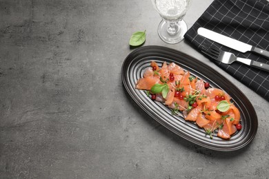 Photo of Delicious salmon carpaccio served on grey table, flat lay. Space for text