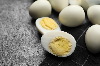 Peeled hard boiled quail eggs on grey table, closeup. Space for text