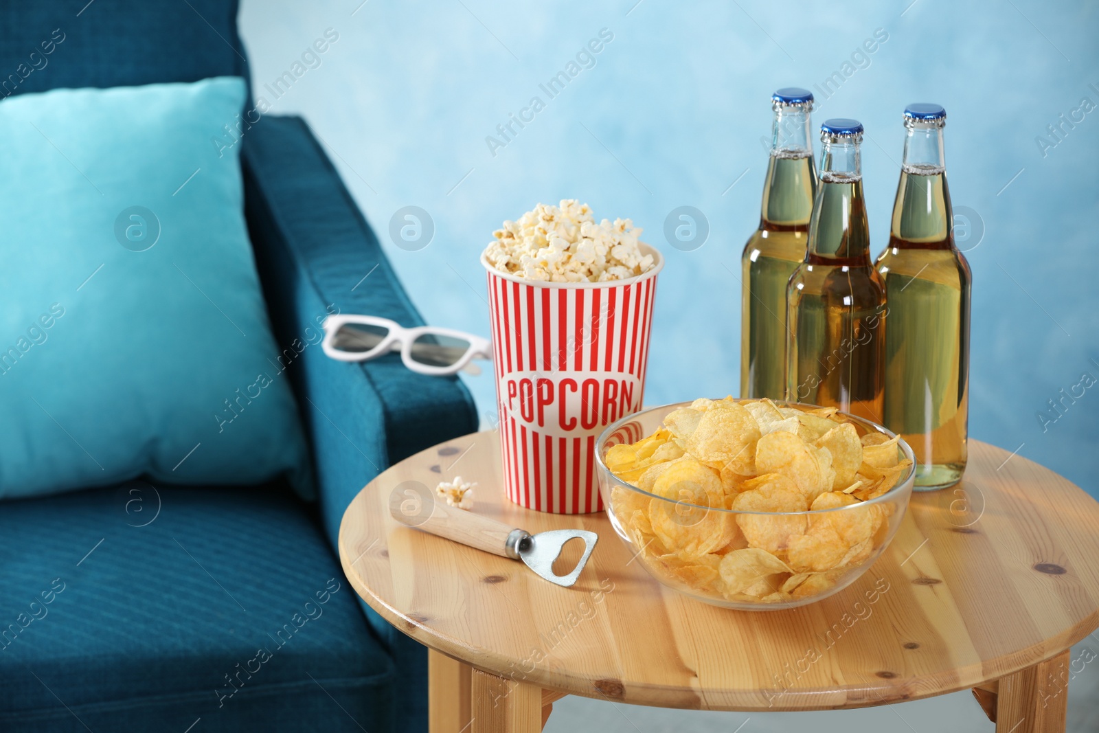 Photo of Beer, snacks and bottle opener on wooden table indoors. Party time