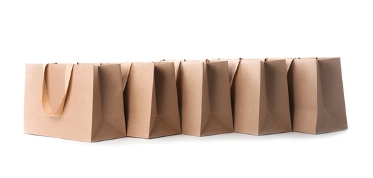 Paper shopping bags with comfortable handles on white background. Mockup for design