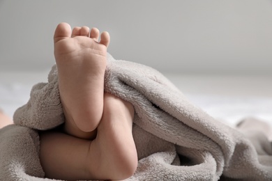 Little baby lying on soft blanket against light background, closeup. Space for text