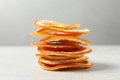 Photo of Stacked dry orange slices on white table