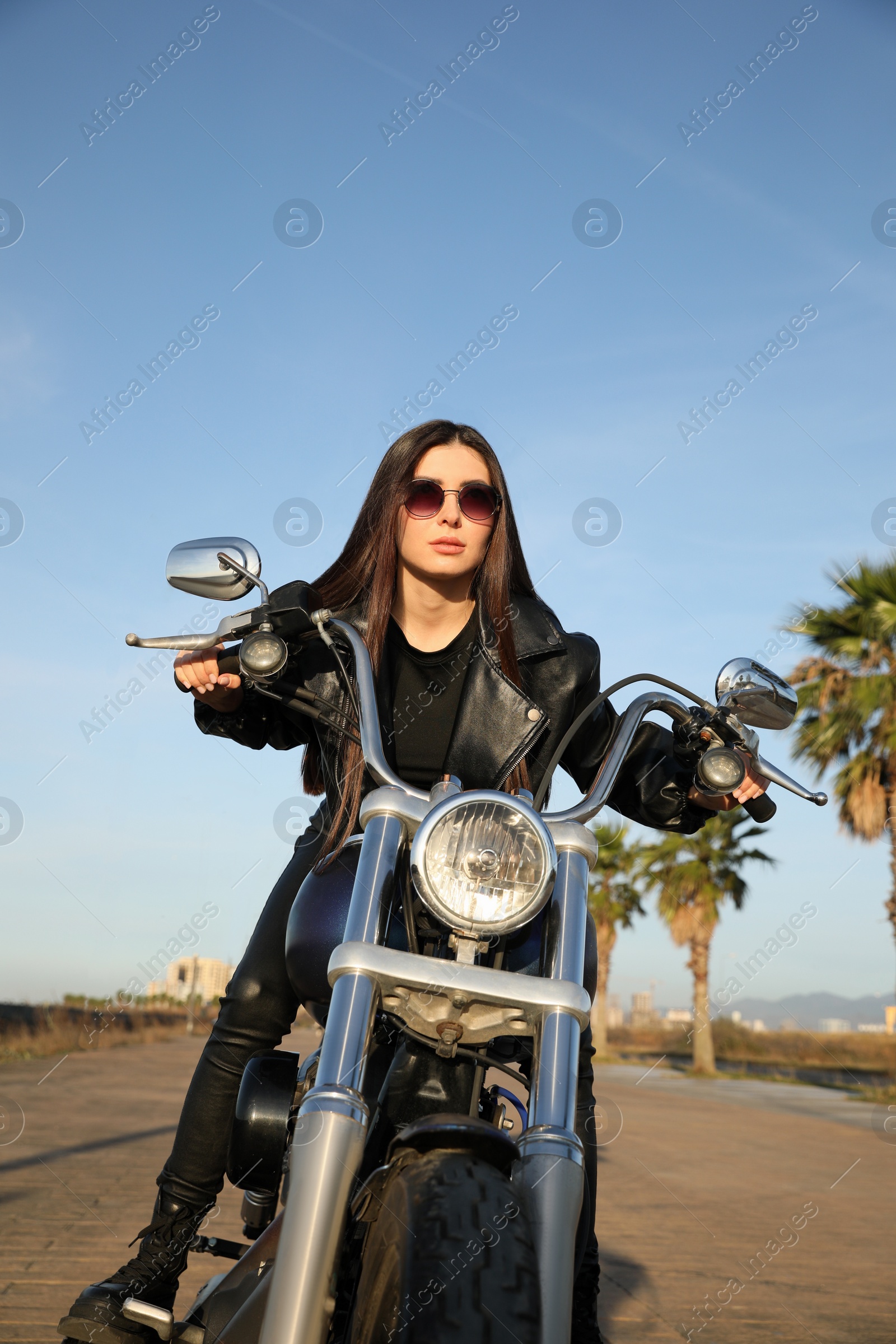 Photo of Beautiful young woman riding motorcycle on sunny day