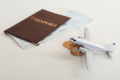 Composition with toy plane, coins and passport on white background. Travel insurance