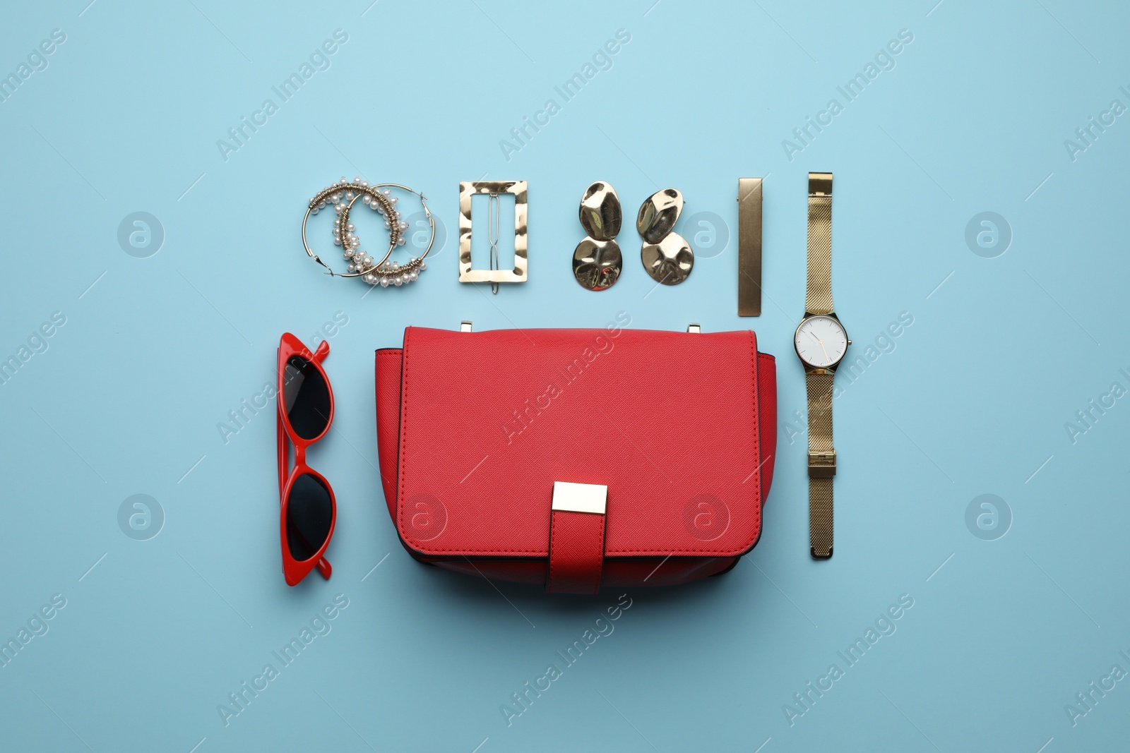 Photo of Stylish woman's bag and accessories on light blue background, flat lay