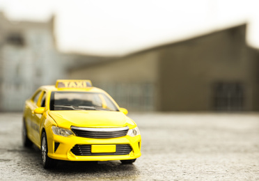 Yellow taxi car model on city street