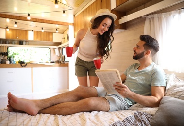 Photo of Happy young couple spending time together in trailer. Camping vacation