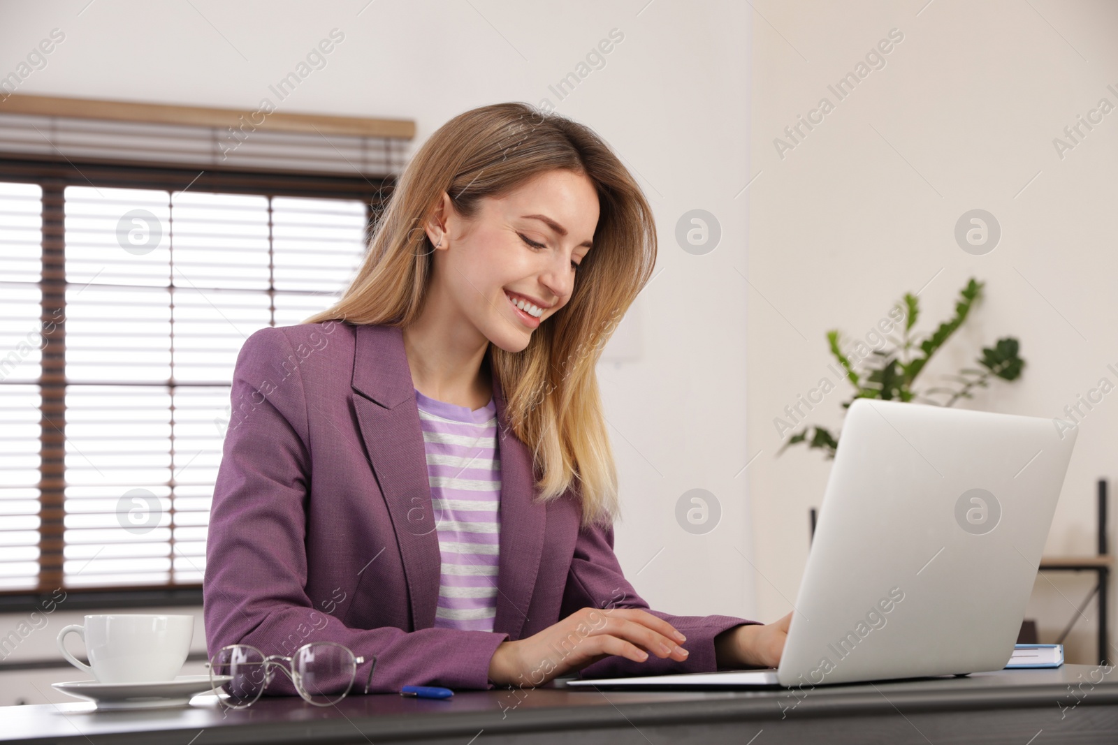 Image of Young woman working on laptop in office