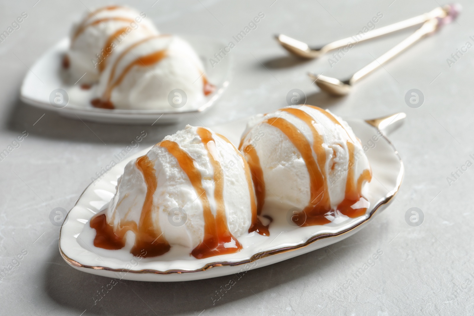 Photo of Tasty ice cream with caramel sauce on plate