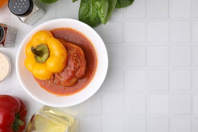 Photo of Delicious stuffed bell pepper served on white tiled table, flat lay. Space for text