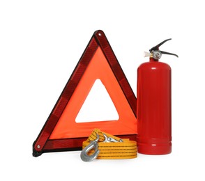 Photo of Emergency warning triangle, towing strap and red fire extinguisher on white background. Car safety