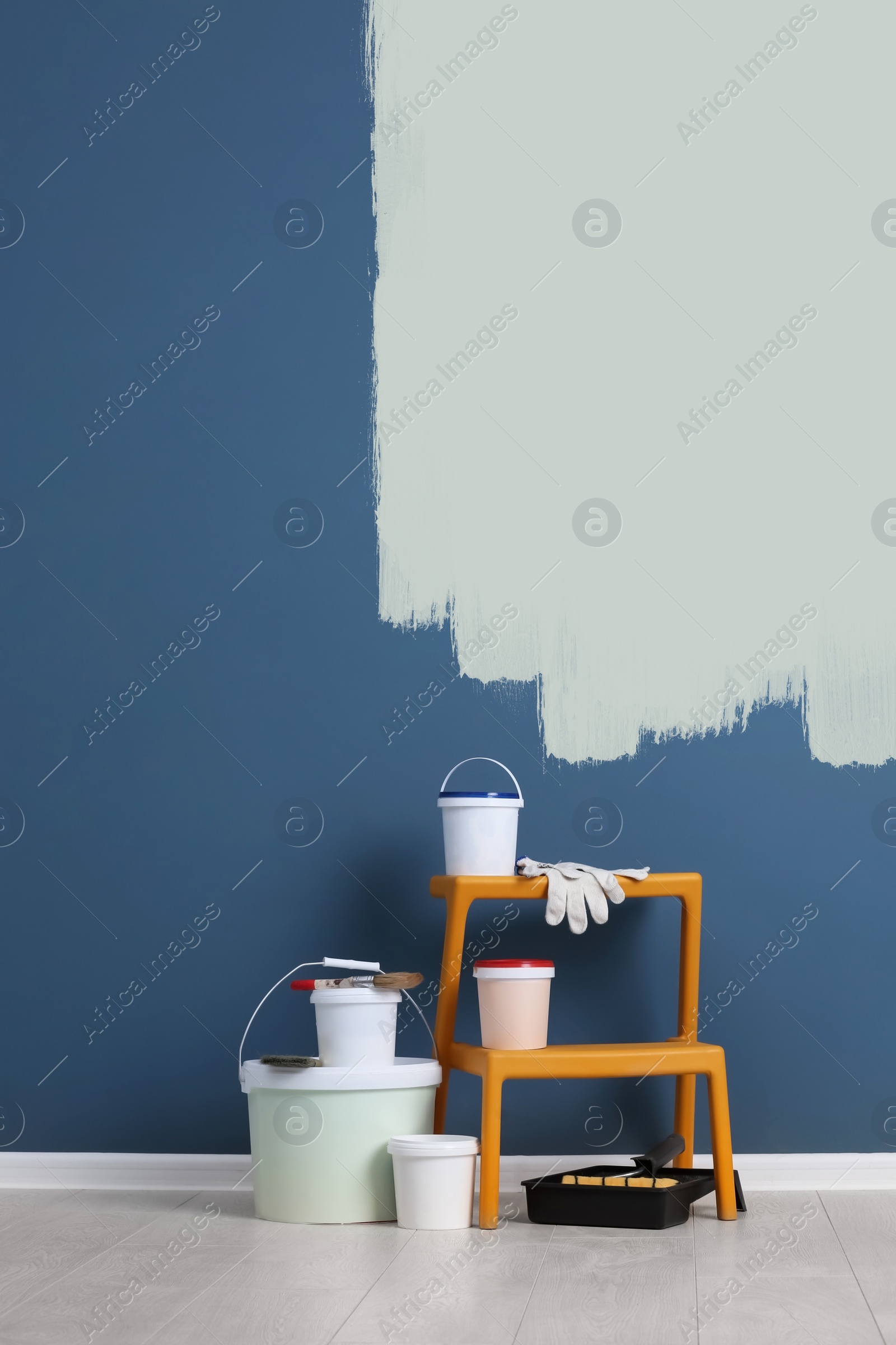 Image of Set with decorator tools and paint on floor near color wall