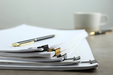 Photo of Stack of documents with binder clips on light table, closeup