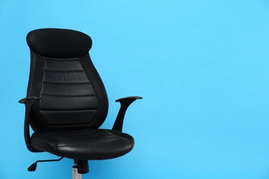 Photo of Comfortable office chair on light blue background, space for text