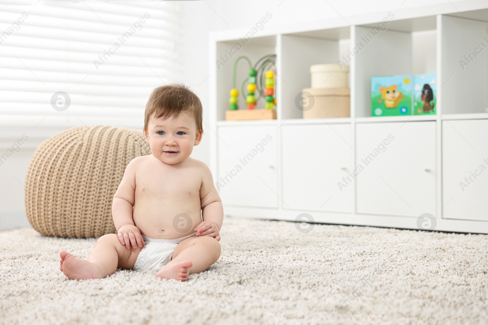 Photo of Cute baby boy sitting on carpet at home. Space for text
