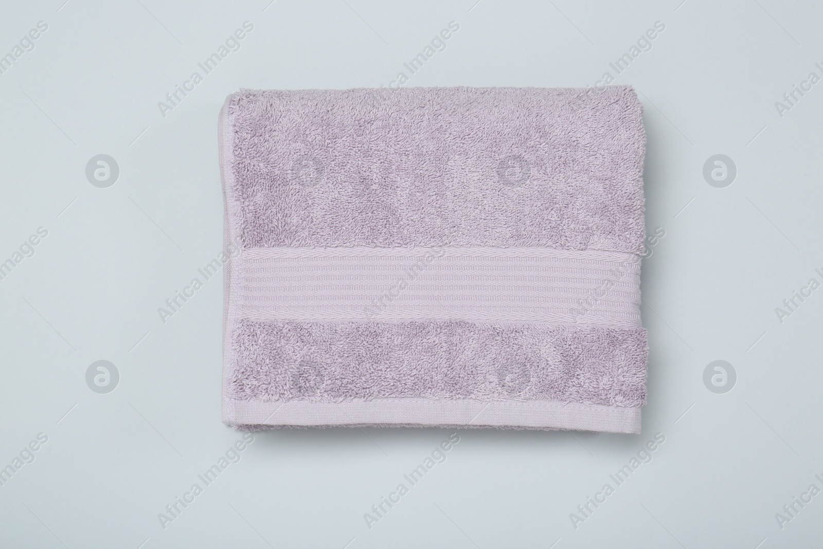 Photo of Violet terry towel on light grey background, top view