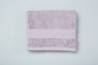 Photo of Violet terry towel on light grey background, top view