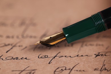 Photo of Elegant fountain pen on handwritten letter, closeup