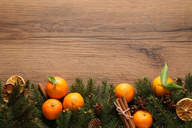 Photo of Christmas composition with tangerines on wooden background, flat lay. Space for text