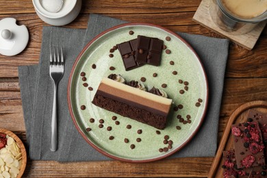 Photo of Tasty chocolate mousse cake and ingredients on wooden table, flat lay
