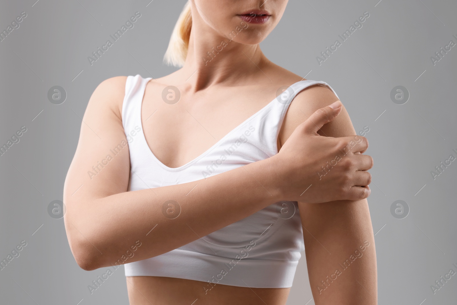 Photo of Woman with sporty body on grey background, closeup