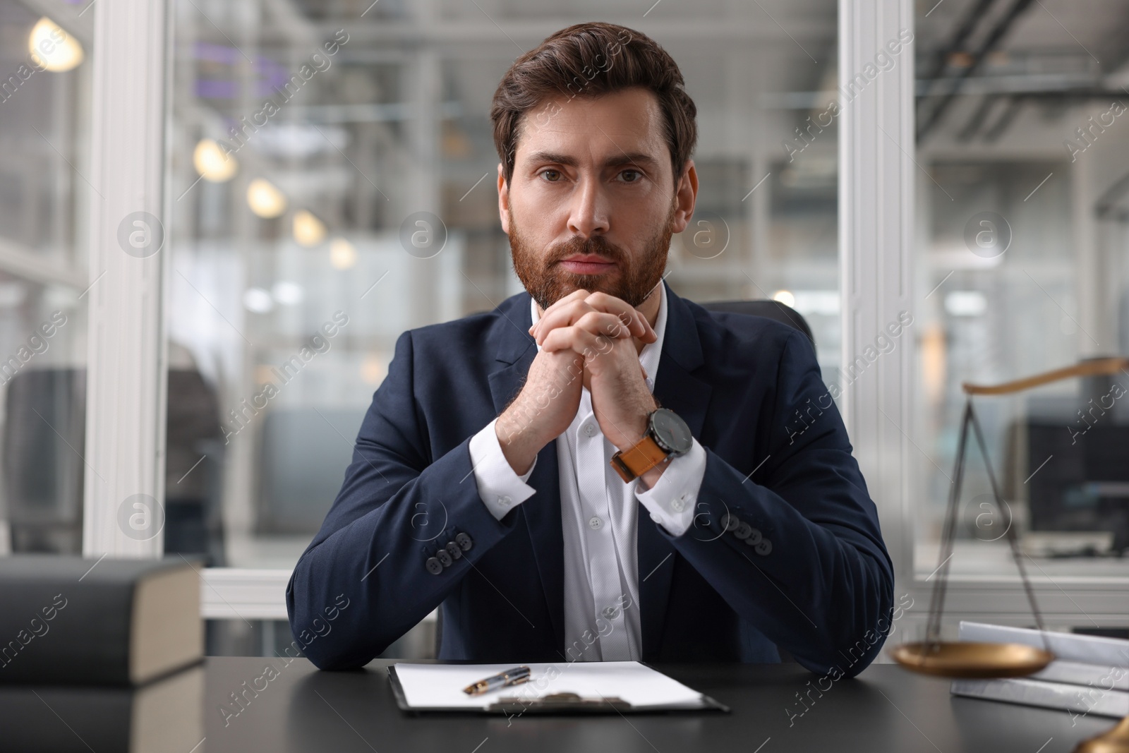 Photo of Portrait of confident lawyer at table in office