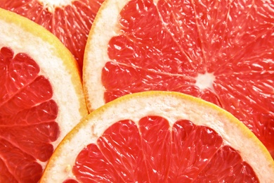 Photo of Many slices of fresh ripe grapefruits as background, closeup