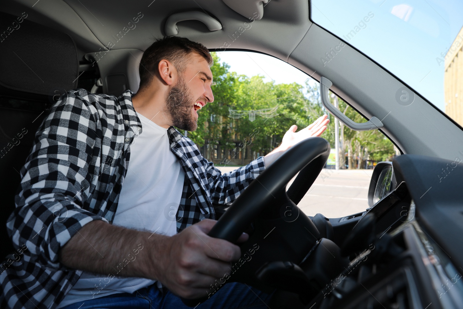 Photo of Emotional man in car. Aggressive driving behavior