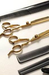 Hairdresser tools. Different scissors and combs on white table, closeup