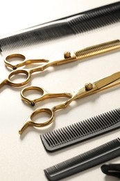 Photo of Hairdresser tools. Different scissors and combs on white table, closeup