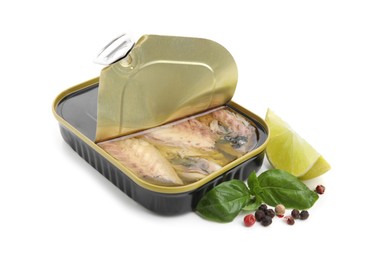 Open tin can with mackerel fillets, lime, peppercorns and basil on white background