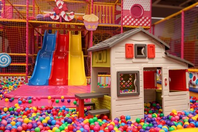 Slides, playhouse and many colorful balls in ball pit
