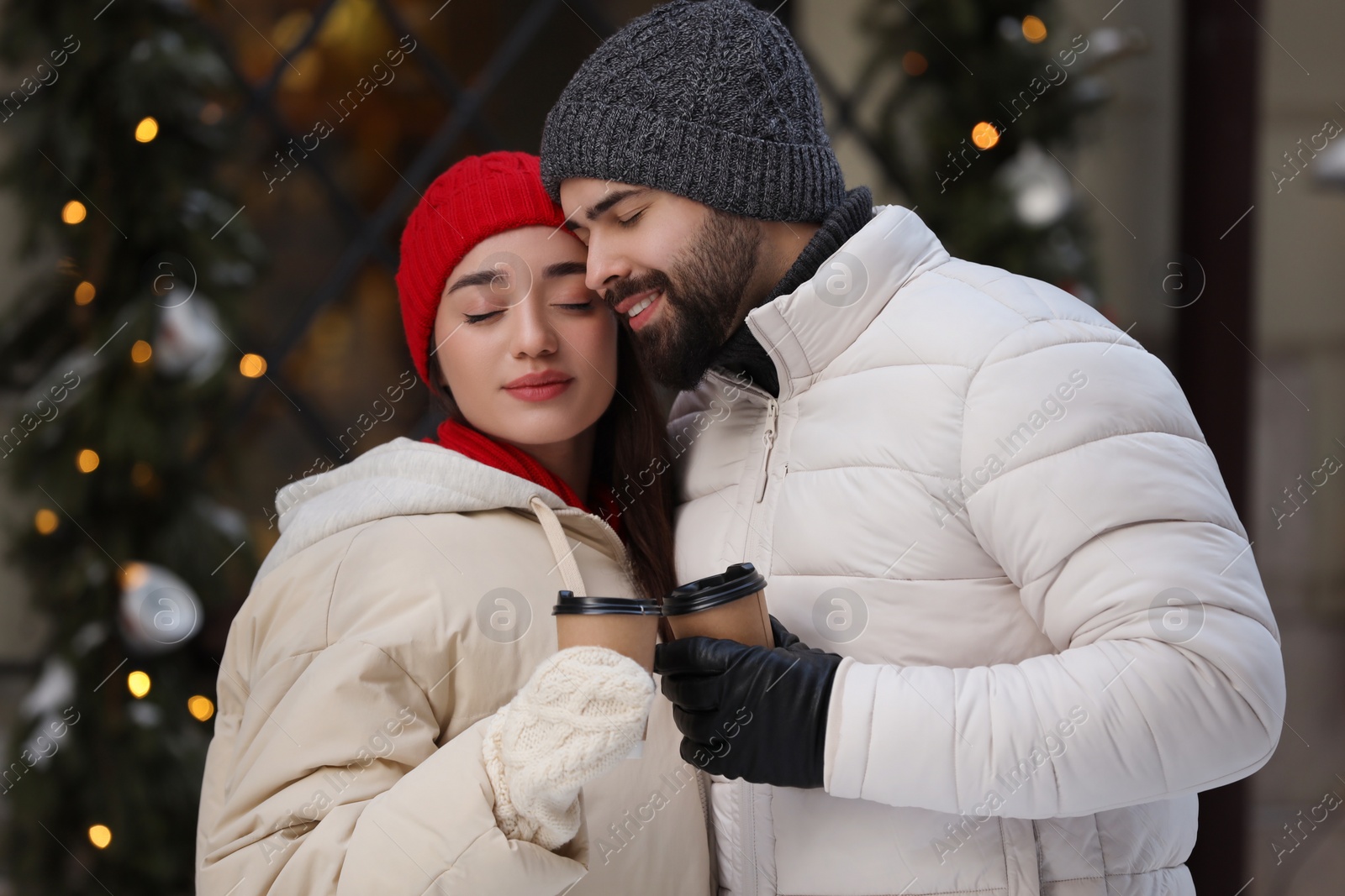 Photo of Lovely couple with hot drinks spending time together outdoors