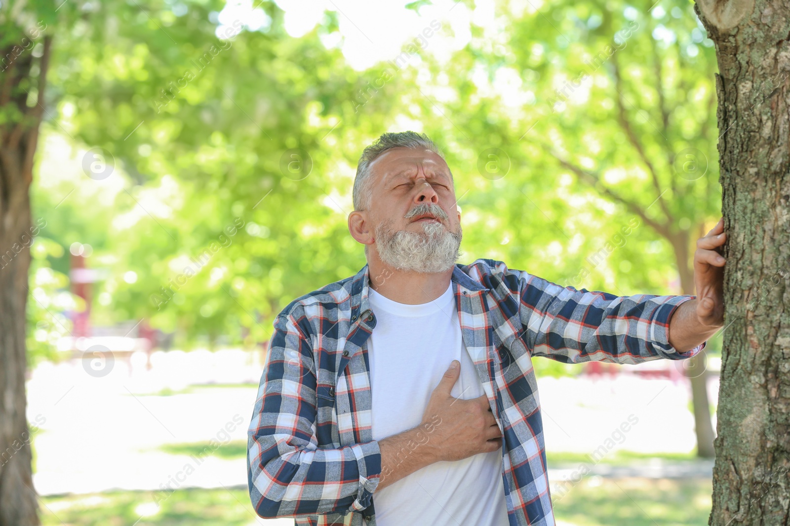 Photo of Mature man having heart attack in park